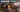 AI-generated illustration of TV speakers and headphones playing together in a Hong Kong living room, with two separate headphones shown in an inset.
