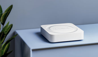Compact white square Reolink NVR sitting on a light blue cabinet
