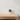 EZVIZ H1C standing on a wooden cabinet against a white wall