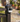 White Reolink Argus MagiCam attached to a black metal fence post in a garden