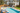 Wide view of a back garden with a pool, people and a house