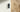 Black doorbell with a lit blue ring mounted beside a wooden front door