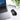 iClever MD172 black ergonomic mouse on a white desk beside a laptop and glasses