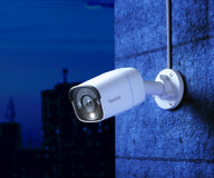 White Reolink RP-PCB8M bullet camera mounted on an outdoor wall at dusk
