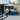Man carrying a parcel with a dog and an SUV, each marked by detection icons