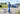Man walking a dog past a pickup truck, each outlined by person, animal and vehicle detection boxes