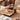Hand placing a phone on the dock of the yellow printer as a photo prints on a wooden desk